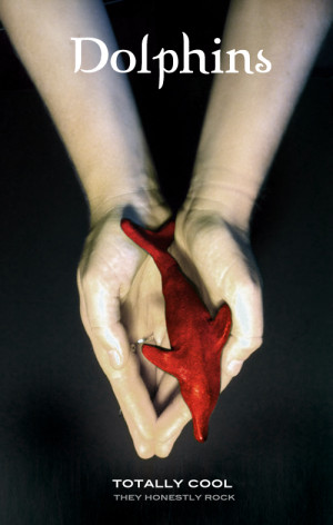 Photo of outstretched hands holding a red dolphin.